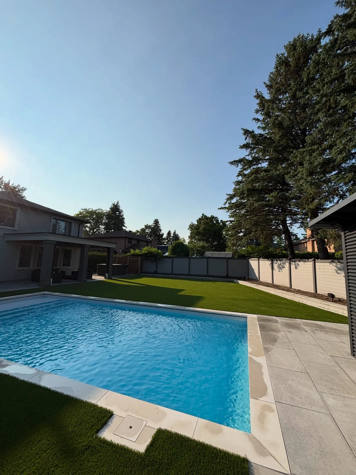 Artificial grass installed around a backyard pool in Pickering